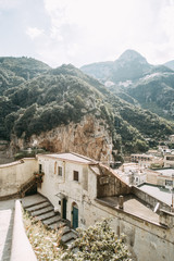 Obraz premium The Amalfi coast and the mountain slopes with plantations of lemons. Panoramic view of the city and nature of Italy. Evening landscapes and winding roads