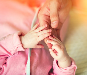 Newborn baby holds father's hand