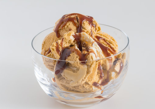 Ice cream in glass bowl - Caramel and vanilla ice cream drizzled with chocolate syrup close up.