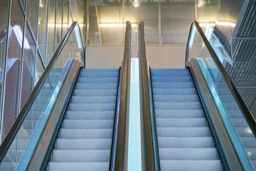 Escalators in an office building. Empty escalator stairs. Modern escalator in shopping mall, Department store escalator. Empty escalator inside a glass building.