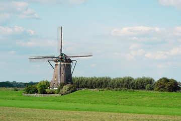 Obraz premium Old windmill against the blue sky in the morning in the summer. An old white mill. 