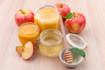 Jewish holiday Rosh Hashanah background with honey and apples on wooden table.