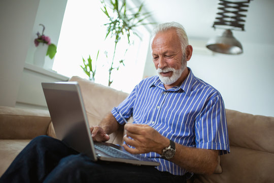 Senior man doing online shopping while sitting at home