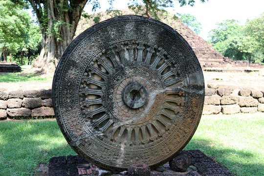 Stone carving of the wheel of the dharma. in archaeological site of Srithep ancient town in Petchaboon, Thailand. The influence of ancient Draravati culture, 8th-9th century A.D.