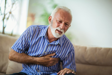 Senior man suffering from heart attack at home
