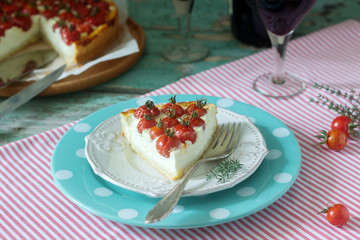 Tart, pie or cheesecake with cottage cheese and tomatoes, served with red wine on a wooden background.