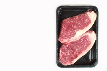 Raw steak in an airtight vacuum package on a white background.