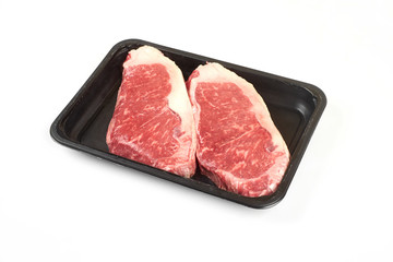 Raw steak in package. Isolated on white background.