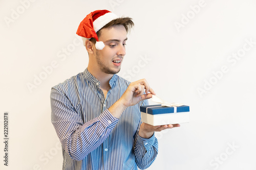 Curious Christmas Guy Opening Gift Box Young Man In Santa Hat Curious Christmas Guy Opening Gift Box Young Man In Santa Hat Unwring Present Package