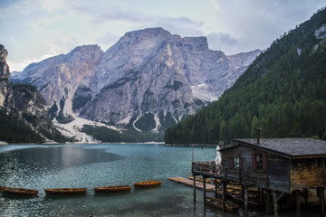 Fototapeta na wymiar Travel Dolomites, Italy.Breathtaking summer landscape view of iconic boathouse and wooden boats on romantic Lago Di Braies (Pragser Wildsee). Tourist popular attraction/destination in South Tyrol Alps