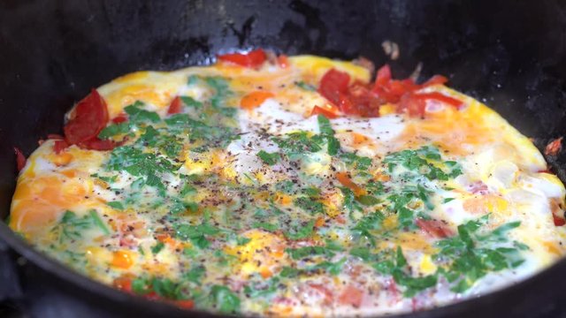 Shakshouka or shakshuka is a North African Jewish origin dish of eggs poached in a sauce of tomatoes, chili peppers and onions, often spiced with cumin. Close up