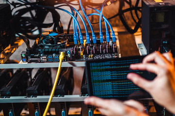 Programmer adjusting cryptocurrency mining rig to optimal operational settings
