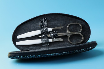A black manicure case with scissors, some nail files and another things.