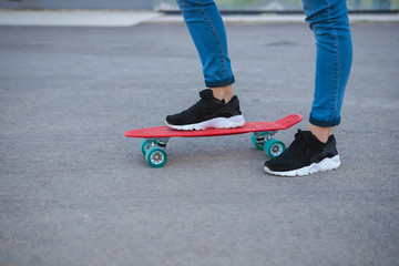 Some of the legs are on a skateboard close up. young sport. leisure. penny board