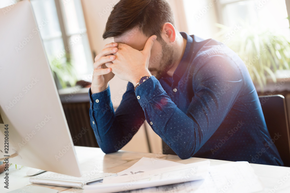 Wall mural Portrait of tired overworked architect in office