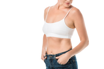 cropped shot of smiling woman in white underwear and jeans isolated on white