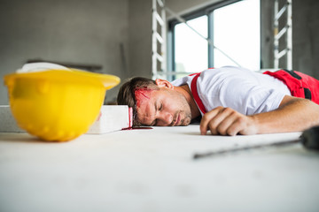 An unconscious man worker lying on the floor after accident on the construction site.