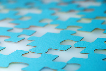 Elements of a puzzle of blue color on a white table.