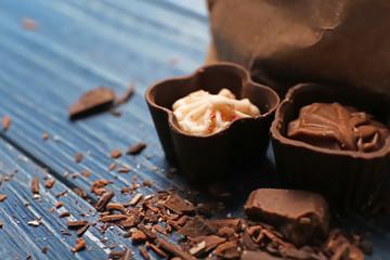Yummy chocolate candies on wooden table