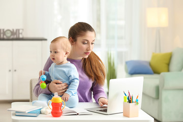 Young mother with baby working at home