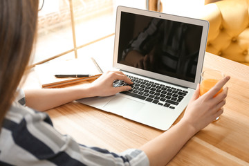 Young freelancer with laptop working in cafe