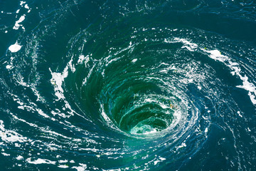 High angle view of a powerful whirlpool at the surface of green water with foam. - obrazy, fototapety, plakaty