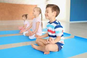 Little children practicing yoga indoors