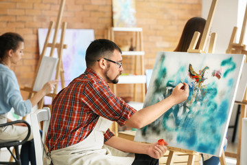 Male student during during classes in school of painters