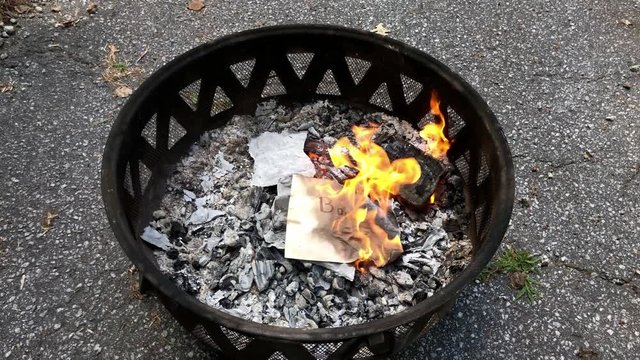 Burning negative words written on paper in fire