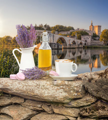 Lavender still life with cup of coffee against Avignon bridge in Provence, France