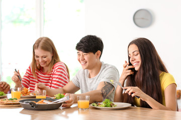Friends eating at table in kitchen