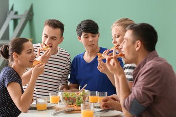 Friends eating at table in kitchen