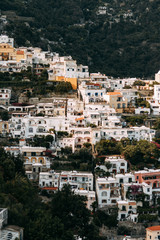 Fototapeta na wymiar The coast of Positano, Amalfi in Italy. Panorama of the evening city and the streets with shops and cafes. Houses by the sea and the beach. Ancient architecture and temples