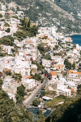 Fototapeta premium The coast of Positano, Amalfi in Italy. Panorama of the evening city and the streets with shops and cafes. Houses by the sea and the beach. Ancient architecture and temples