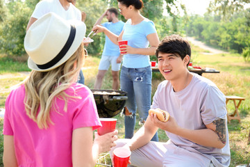 Young people having barbecue party in park