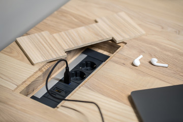 Closeup photo of wooden table with power sockets