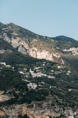 The coast of Positano, Amalfi in Italy. Panorama of the evening city and the streets with shops and cafes. Houses by the sea and the beach. Ancient architecture and temples