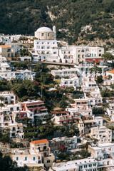 The coast of Positano, Amalfi in Italy. Panorama of the evening city and the streets with shops and cafes. Houses by the sea and the beach. Ancient architecture and temples