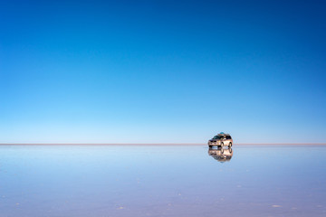 Mirror effect and reflections of a 4x4 car in Salar de Uyuni (Uyuni salt flats), Potosi, Bolivia, South America