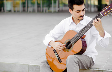 Young professional guitarist playing outside