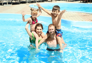 Fototapeta na wymiar Happy family resting in swimming pool
