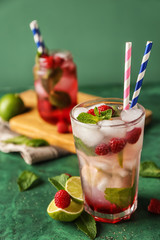 Glass of fresh raspberry mojito on table