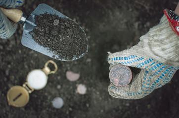 Aged 5 kopeks coin of Russian empire in the hand of coin finder. Treasure hunting concept. In...