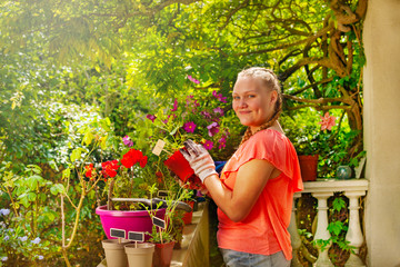 Girl standing on balcony with potted flowers