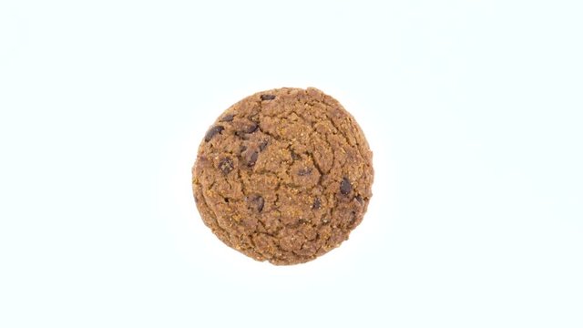 Top view from above of one soft and chewy chocolate chip oatmeal cookies rotating on the turntable. Isolated on the white color background. Close-up. Macro.