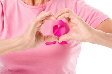 cropped shot of senior woman in pink t-shirt with breast cancer awareness ribbon showing hand heart symbol isolated on white
