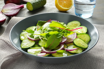 Plate with tasty vegetable salad on table