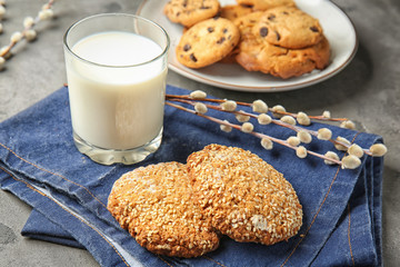 Tasty cookies and glass of milk on grey table