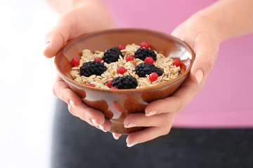 Woman with bowl of tasty oatmeal, closeup