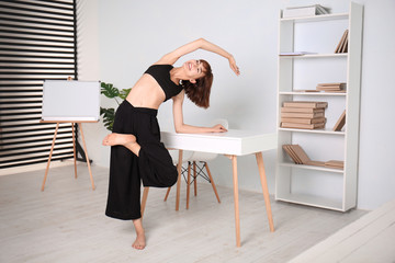 Sporty woman practicing yoga at home